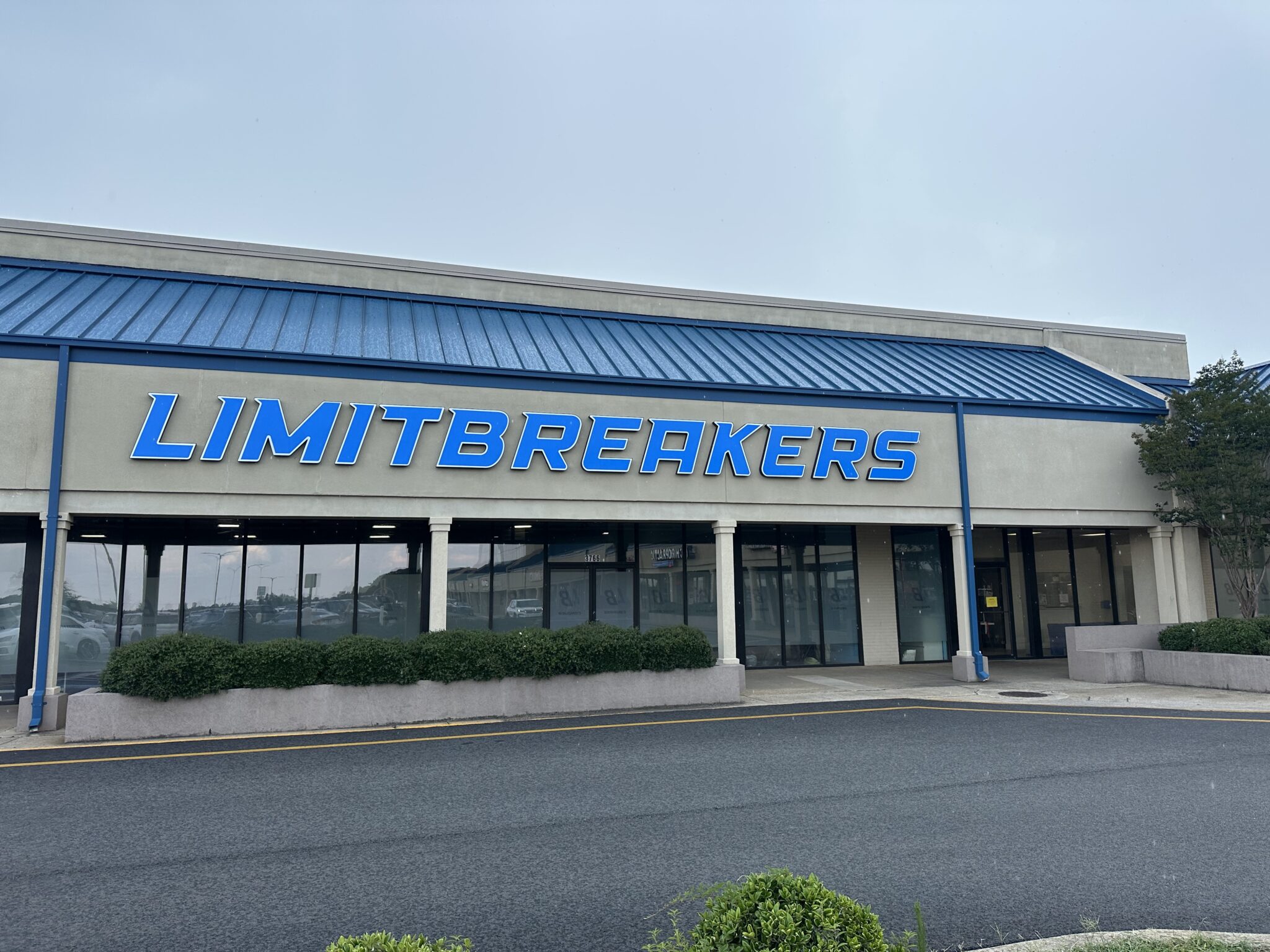 Storefront with "LIMITBREAKERS" sign and blue awning.